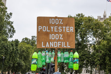 Protest sign highlighting polyester pollution and landfill waste. London, UK, 10 August 2024