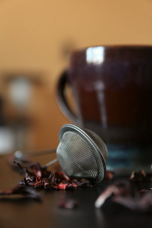 Dark table tea composition. Brown cup. Orange background