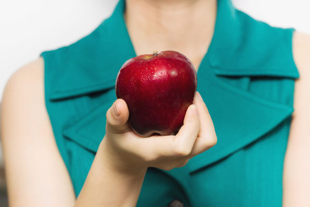 Red apple shiny surface in woman's hand, selective focusの写真素材