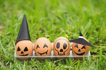 Four halloween egg in egg cup on green grassの写真素材