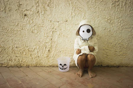 Poor kid waiting for Halloween candy sepia toneの写真素材