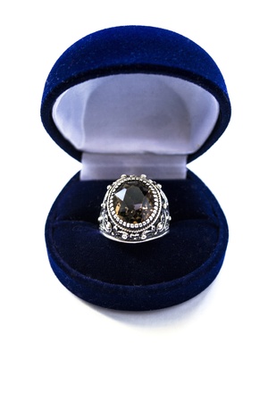 Silver ring with big topaz in a box isolated over whiteの写真素材