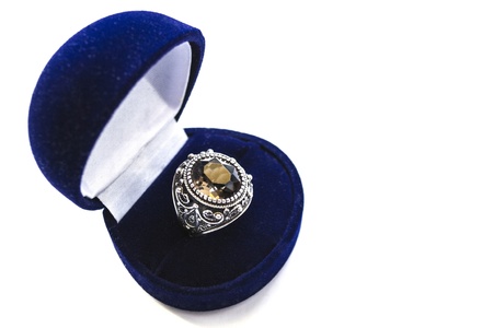 Silver ring with big topaz in a box isolated over whiteの写真素材