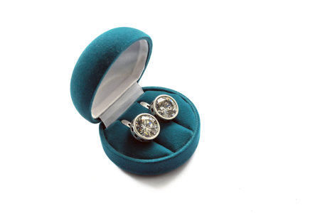 Couple of diamond earrings in a velvet box isolated over white