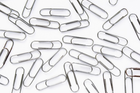 A lot of metal paper clips on light backgroundの写真素材