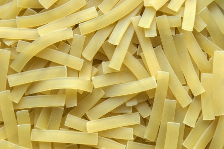 Crude yellow short italian pasta closeup on backgroundの写真素材
