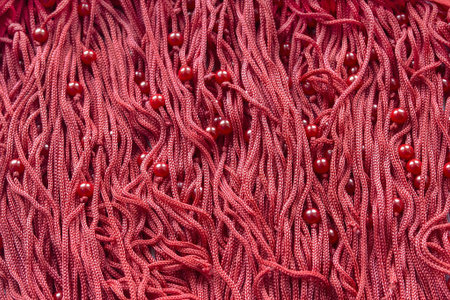 Rich red silky laces with some red beads as a background