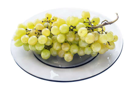 Bunch of yellow grapes on a glass plate on white backgroundの写真素材