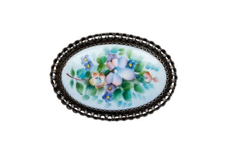 Vintage painted oval metal brooch isolated over whiteの写真素材