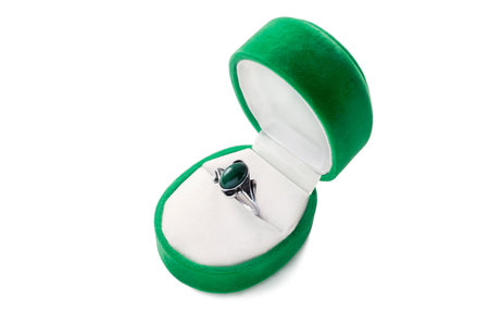 Silver ring with malachite in opened green jewel box isolated over white
