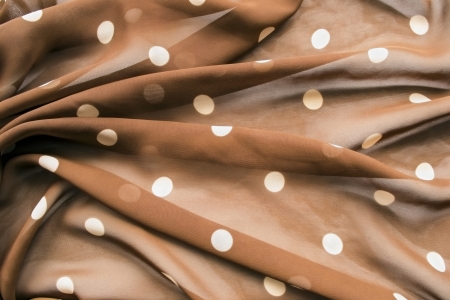 Drapery of silk transparent brown kerchief with white dotsの写真素材