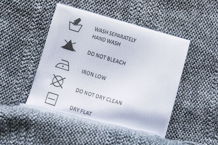 Label with washing instructions on gray knitted fabricの写真素材