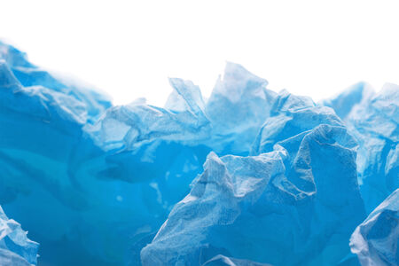 Blue crumpled paper on white abstract as a backgroundの写真素材