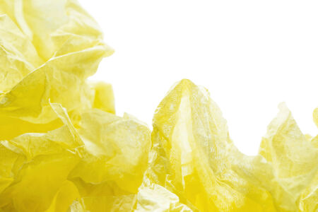 Abstract yellow paper crumpled over white as a backgroundの写真素材