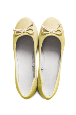 Yellow textile flat shoes isolated over whiteの写真素材
