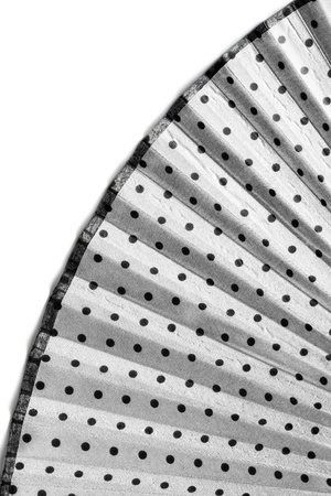 Part of opened textile white fan with black dots on white as a backgroundの写真素材