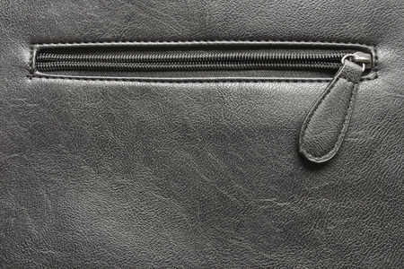 Unfastened zipper on black leather closeup as a backgroundの写真素材