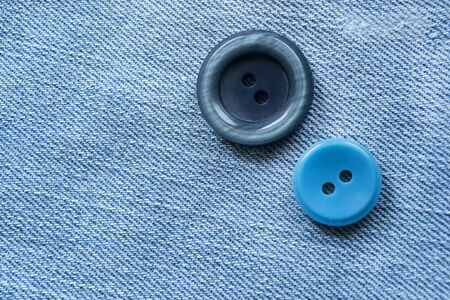 Pair of blue buttons on blue denim cloth as a backgroundの写真素材