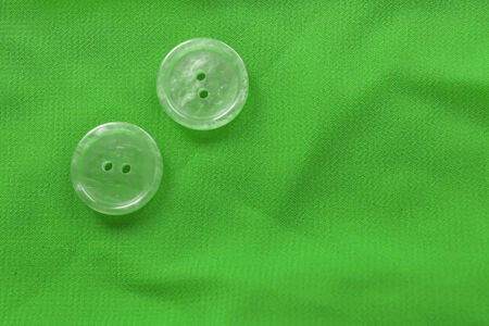 Green silk with pair of glass buttons closeup as a backgroundの写真素材