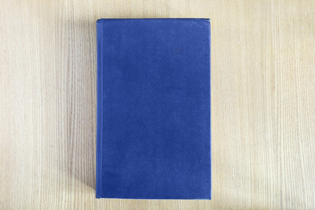 Book with blue blank cover on wooden tableの写真素材