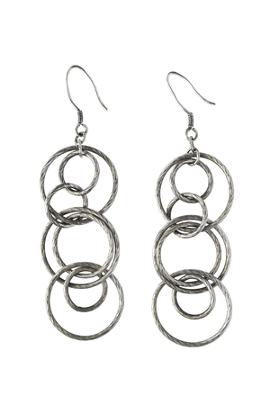 Pair of silver earrings with some rings on white の写真素材