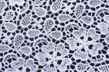 White lace over dark blue closeup as a backgroundの写真素材