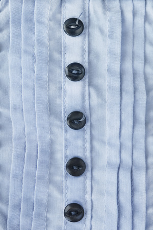 Buttons on blue garment closeup as a backgroundの写真素材