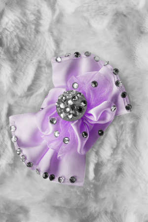 Satin purple brooch with some crystals on white fur as a backgroundの写真素材
