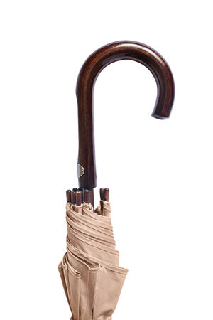 Wooden handle of beige umbrella on white background closeupの写真素材
