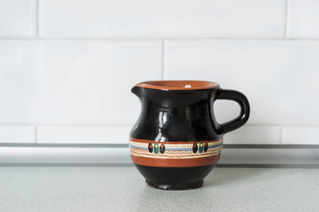 Black ceramic milk jug standing on a tableの写真素材