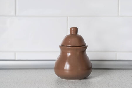 Brown ceramic pot against white wall on a tableの写真素材