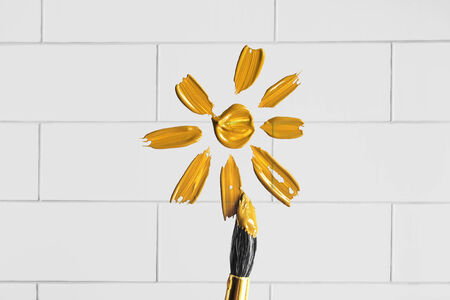 Yellow sun painted on white brick wall as a backgroundの写真素材