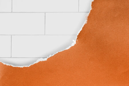 Orange torn paper over white brick wall as a backgroundの写真素材