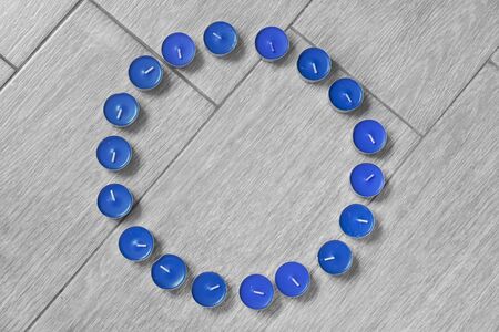 Blue candles in the shape of a circle on wooden backgroundの写真素材