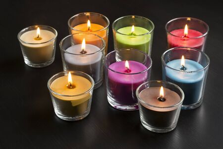 Burning candles in glass candlestics on dark wooden backgroundの写真素材