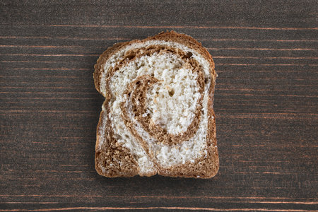 Piece of mixed rye-wheaten bread on wooden backgroundの写真素材