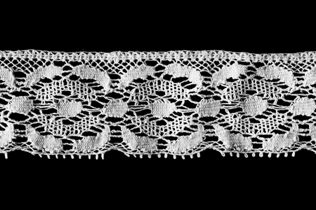 Tape of white vintage lace on black backgroundの写真素材