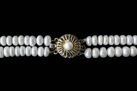 Gilded vintage clasp on pearl necklace isolated over blackの写真素材