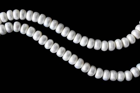 Strings of white pearl isolated over blackの写真素材