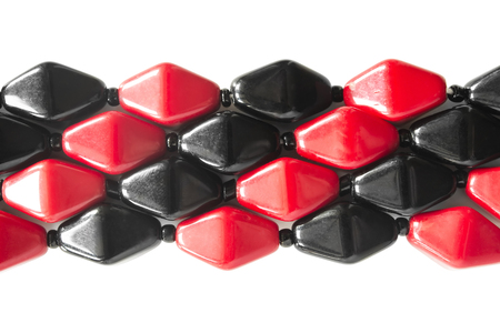 Red and black glass beads on white as a backgroundの写真素材