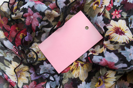 Pink blank label on draped colorful silk as a backgroundの写真素材