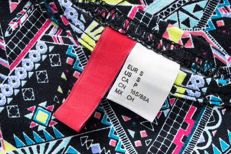 Clothes labels on bright colorful cloth as a backgroundの写真素材