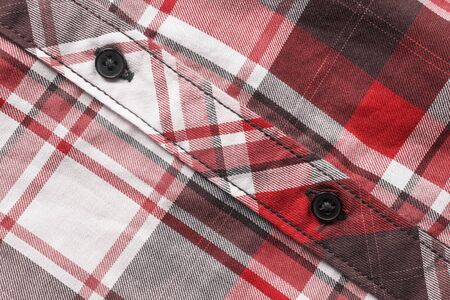 Black buttons on red tartan shirt as a backgroundの写真素材