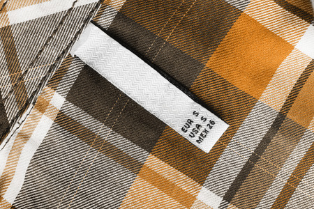 White label on yellow tartan cloth as a backgroundの写真素材