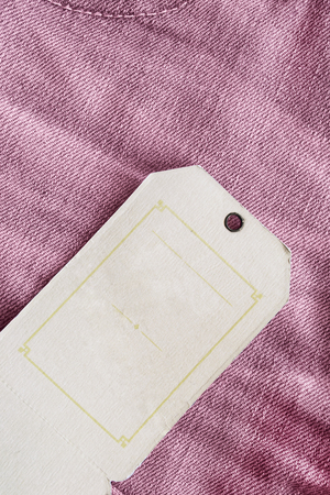 Blank beige label on pink denim as a backgroundの写真素材