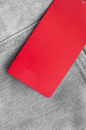 Red blank label on gray denim as a backgroundの写真素材