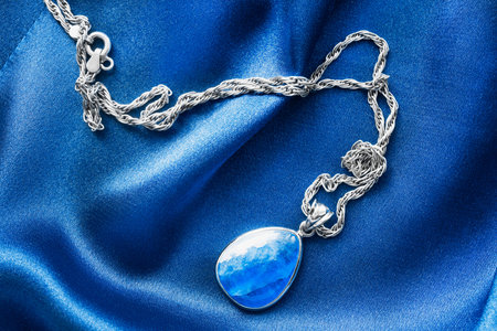 Topaz pendant on blue draped silk as a backgroundの写真素材