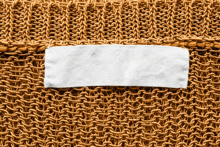 White blank label on golden knitted cloth as a background
