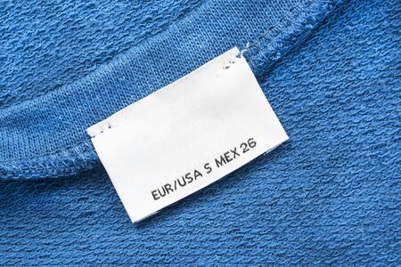White clothes label on blue cotton as a backgroundの写真素材