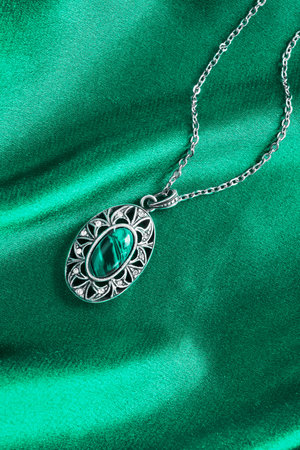 Turquoise silver pendant on blue silk as a backgroundの写真素材